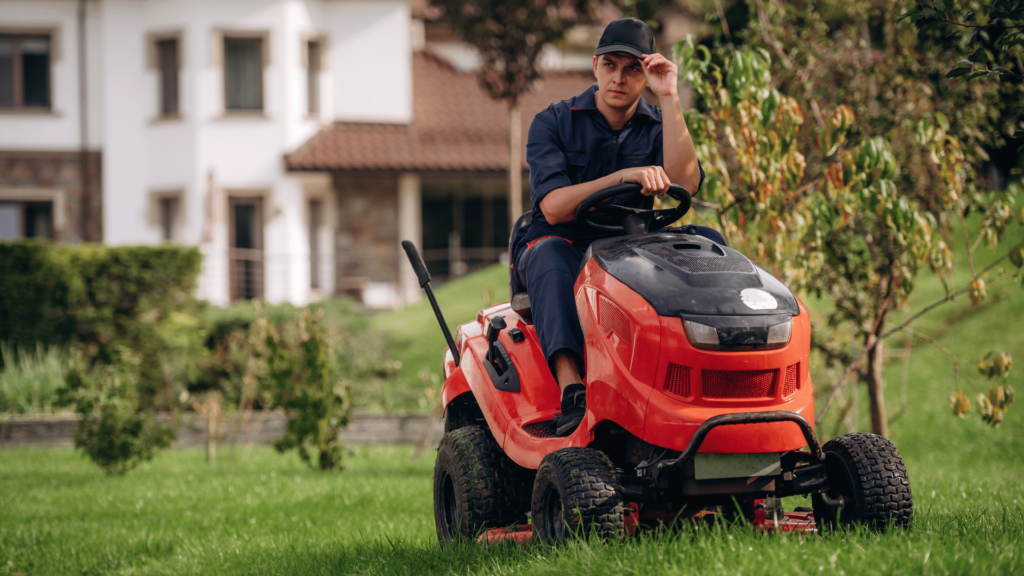 A member of the lawn care crew on a riding lawn mower.